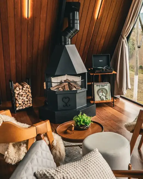 A lareira à lenha entre as poltronas, com a vitrola e os discos ao lado